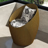 Fauteuil oeuf rotin marron doré sur un balcon