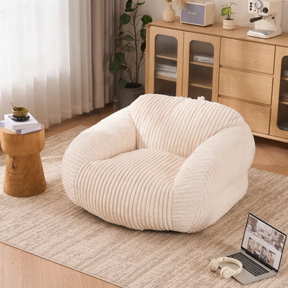 Fauteuil pouf adulte en velours côtelé blanc ivoire dans un salon lumineux