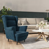 Fauteuil velours bleu à oreilles dans un salon lumineux