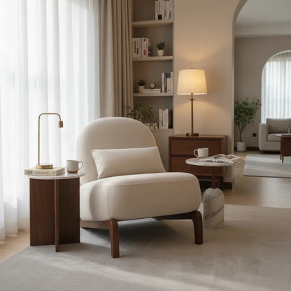 Chauffeuse velours crème dans un salon avec bibliothèque