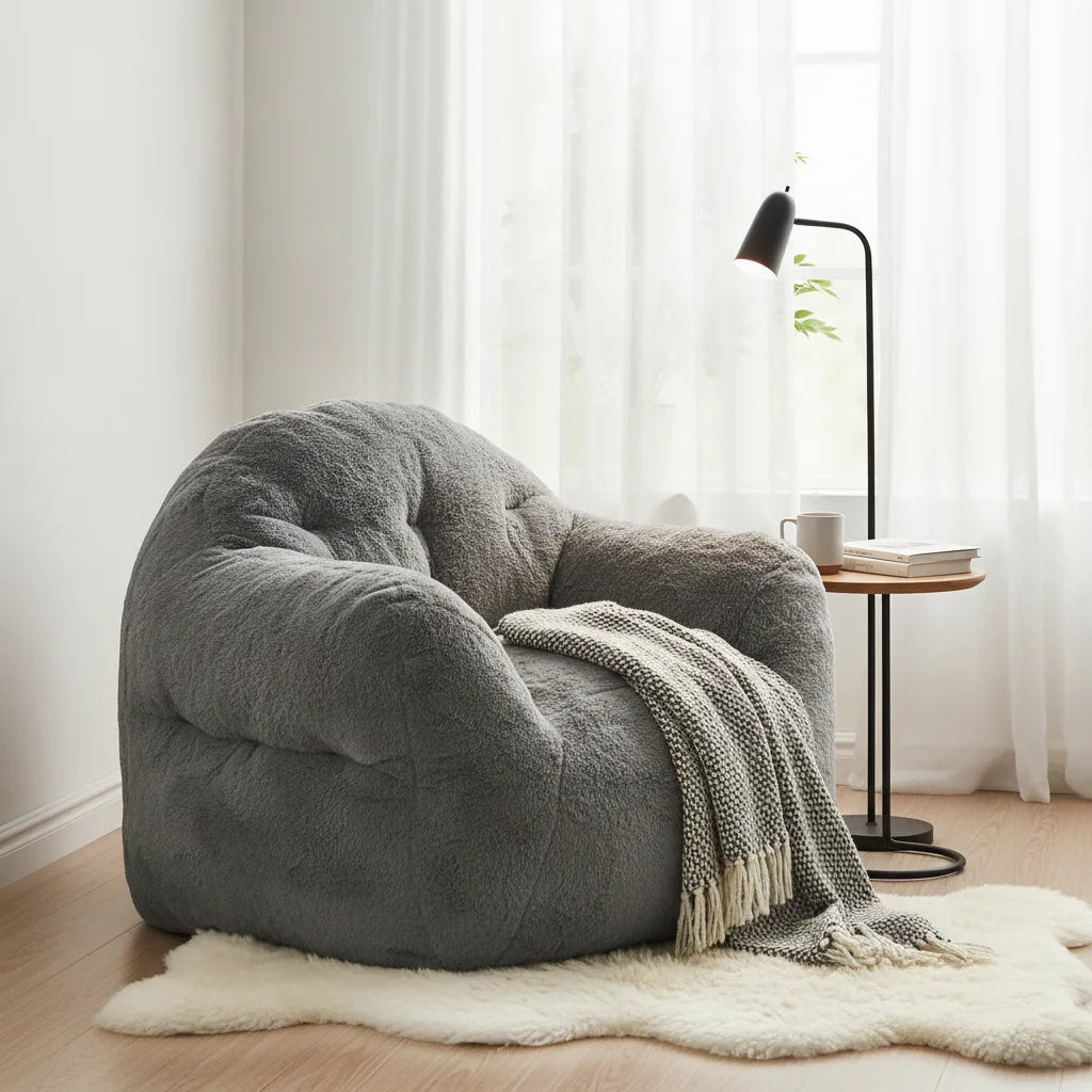 Pouf géant gris avec plaid près d'une fenêtre