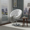 Fauteuil cocktail blanc capitonné avec plaid près d'une baie vitrée