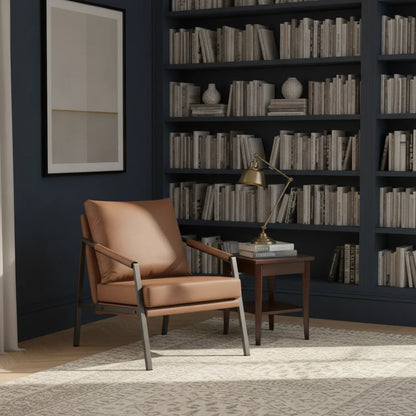 Fauteuil cuir et métal marron cognac dans une bibliothèque