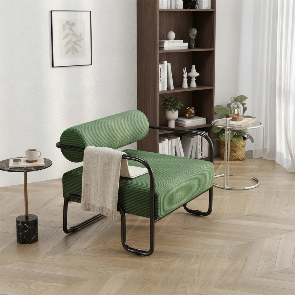 Fauteuil velours côtelé coloris Vert Mousse avec plaid, près d'une bibliothèque