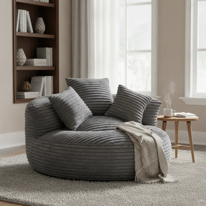 Fauteuil paresseux gris anthracite avec plaid devant une bibliothèque