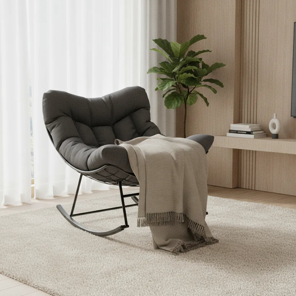 Rocking chair oversize gris anthracite à côté d'une plante verte