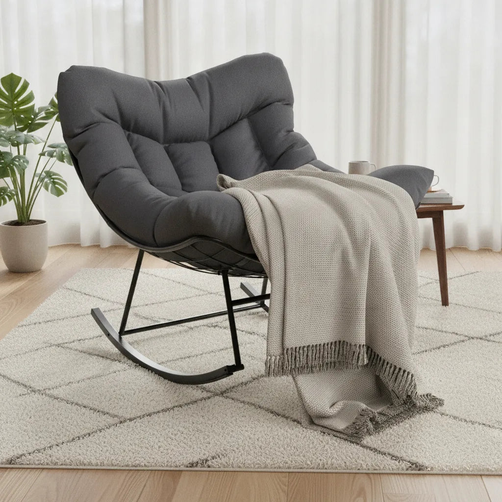 Fauteuil à bascule rocking chair gris avec coussin matelassé et plaid