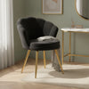 Fauteuil coquillage noir à pieds dorés dans un salon