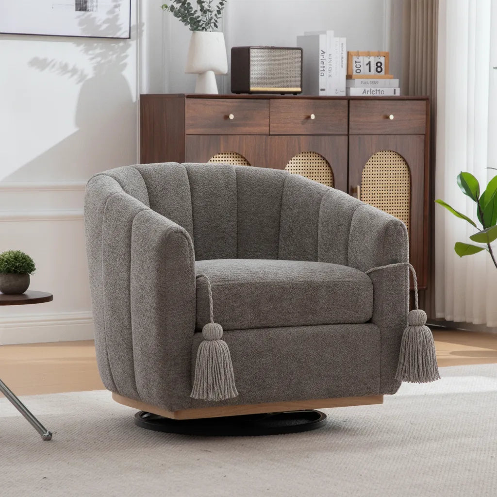 Fauteuil club pivotant en chenille grise avec pompons décoratifs, vue de trois quarts